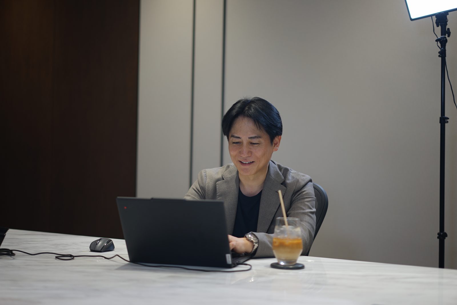 PC を見ながら笑う小庭淳さん