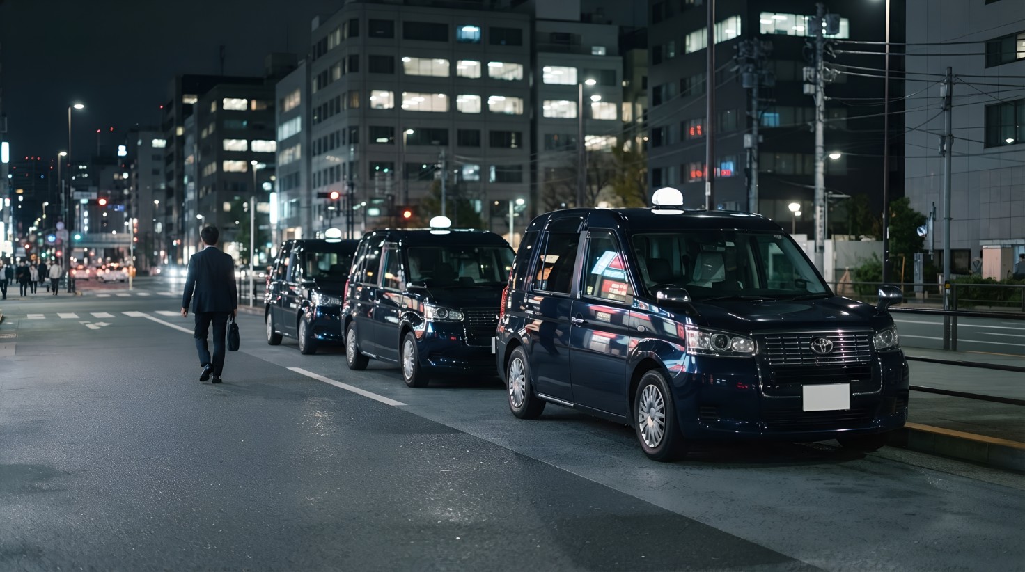 夜のオフィス街に並ぶタクシー